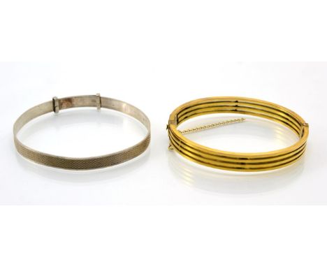 A hinge opening bangle, of four bars, measures 5cm by 6cm, width 1cm, stamped '9CT' and a silver engine turned bangle (2)bang