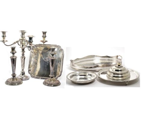 A quantity of silver plate comprising a pair of Old Sheffield plate candlesticks; a five light candelabrum,two salvers; a tra