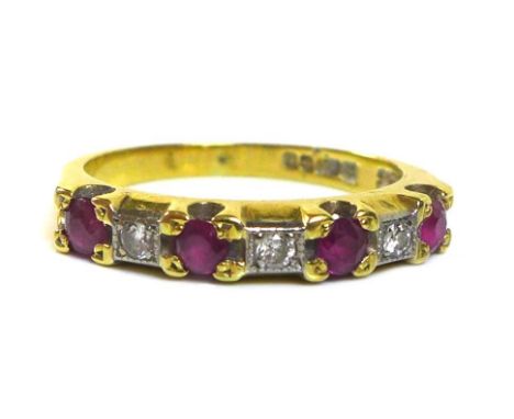 An 18ct gold, ruby and diamond seven stone ring, each of the four rubies of approximately 2.8mm, intersperced with smaller di