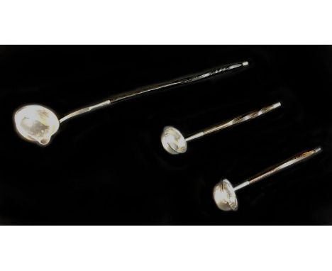 A William IV silver toddy ladle and two others, all with twisted whale bone handles, comprising a William IV Scottish ladle, 