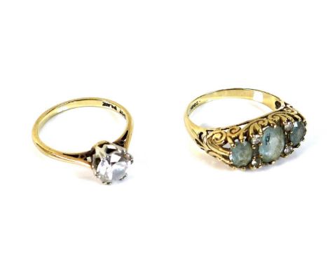 A 9ct gold, aquamarine and diamond ring, with three oval cut aquamarines, 7 by 5mm and 5 by 4mm, interspersed with two pairs 