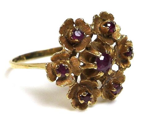 An 18ct gold and ruby ring of repeated flowerhead design, of six florettes, each set with a central ruby surrounding a furthe