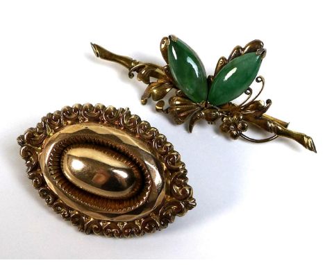 An early to mid 20th century 14ct gold butterfly brooch with jade wings 5.3cm wide, 5.3g, and a yellow metal oval brooch with