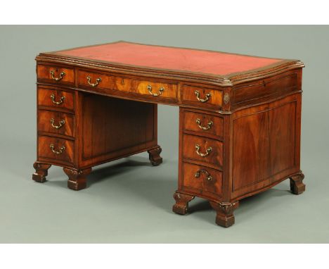 A mahogany Chippendale style pedestal desk, with red tooled leather writing surface and crossbanded moulded serpentine edge a