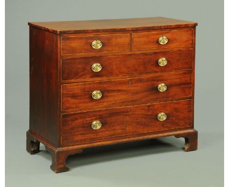 A George III mahogany chest of drawers, with boxwood strung crossbanded edge, two short and three long drawers with brass dro