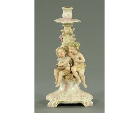 A Meissen style porcelain figural candlestick, raised on a Rococo base.  Height 31 cm.    CONDITION REPORT:  This is the base