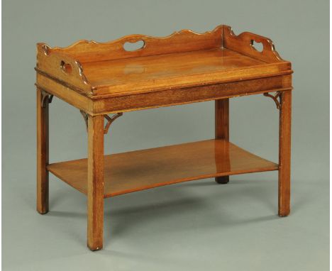 A mahogany coffee table, in the George III style, with butlers tray fixed top and raised on legs of square section with shelf