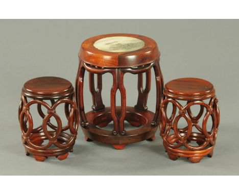 A Chinese hardwood vase stand, mid 20th century, of pierced drum form, the top inset with marble, and a smaller pair of hardw