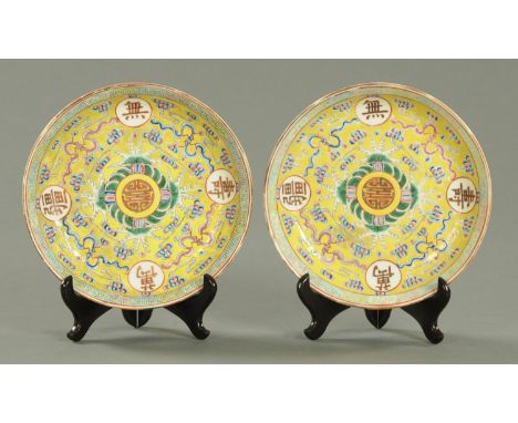 A pair of Chinese yellow ground dished plates, Republic period, decorated with a central Shou within a wave border and with W
