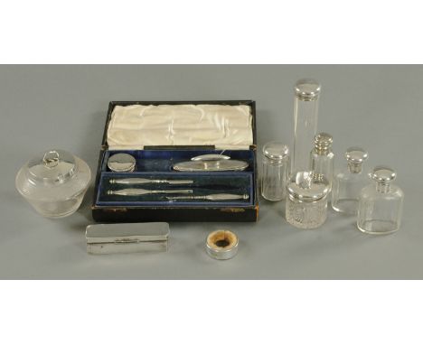 A silver mounted part manicure set, five glass dressing table bottles with silver mounts, a cut glass preserve pot with silve