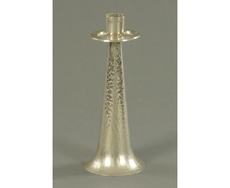 A planished metal candlestick, of inverted tapering form, with soldered seams.  Height 24 cm.