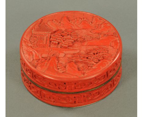 A red cinnabar lacquer cylindrical box and cover, 20th century, the cover decorated with pine trees and buildings and mountai