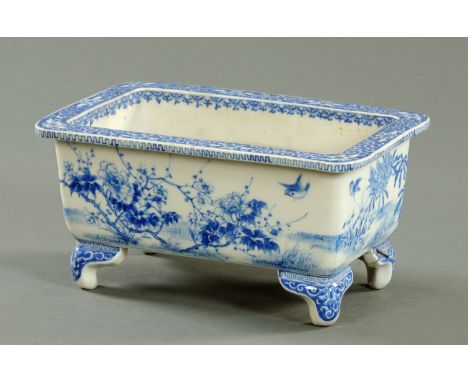 A Japanese Seto blue and white planter, circa 1900, of rectangular form, the rim decorated with scrolls above a combed edge, 