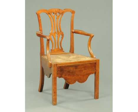 An early 19th century fruitwood armchair, in the Chippendale style, with rush seat and shaped apron.