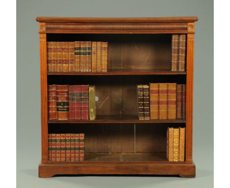 An Edwardian walnut open bookcase, with moulded edge and quarter round moulded frieze above a series of adjustable shelves fl