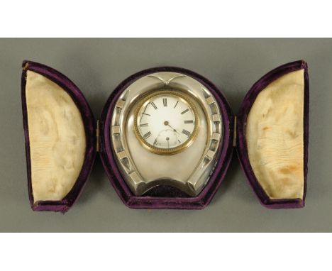 A silver novelty desk clock in the form of a horseshoe, Douglas Clock Co, Birmingham 1897, gilt metal back and easel support,