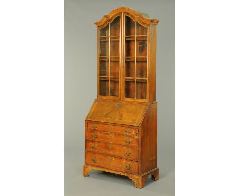 A Queen Anne style walnut bureau bookcase, with moulded cornice above a pair of glazed doors, the base with slope front above