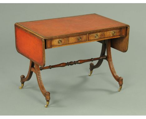 A Regency style mahogany reproduction sofa table, with red leather surface, crossbanded edge and with two frieze drawers, rai