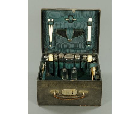 A leather travelling toiletry set, with five matching silver topped jars, London 1903, and with four further silver topped bo