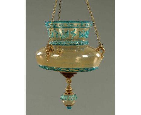 A light amber coloured glass mosque lamp, late 19th/early 20th century, with trailed blue calligraphic and geometric band dec