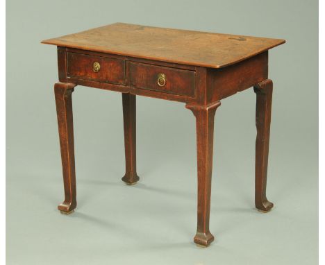 An early 18th century oak and elm side table, fitted with two frieze drawers with ring handles and raised on cabriole legs.  