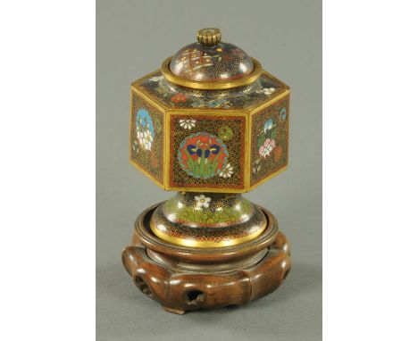 A Japanese cloisonne vase and cover, Meiji period, with Kiku knop above the hexagonal body with panels of floral mons upon a 