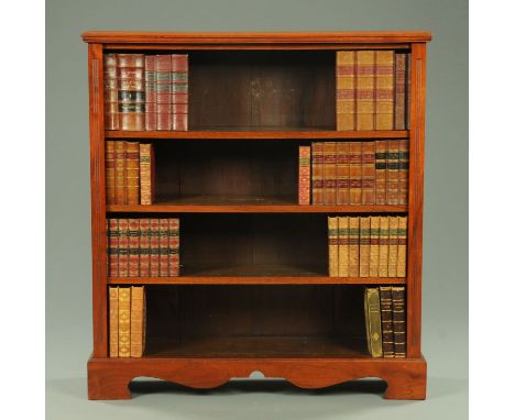 An Edwardian walnut open bookcase, with moulded edge above a series of open shelves flanked by flat pilasters and raised on b