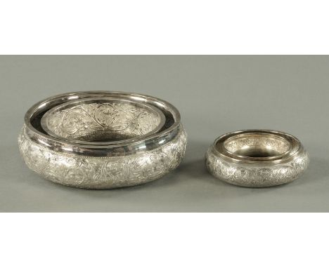 Two Malaysian silver posy ring bowls, 20th century, decorated with scrolling foliate fronds, the larger struck with Jawi scri