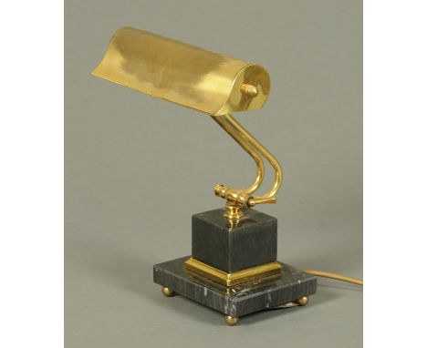 A brass adjustable desk lamp, circa 1970's, supported on a black marble plinth on ball feet.  Height 32 cm. 