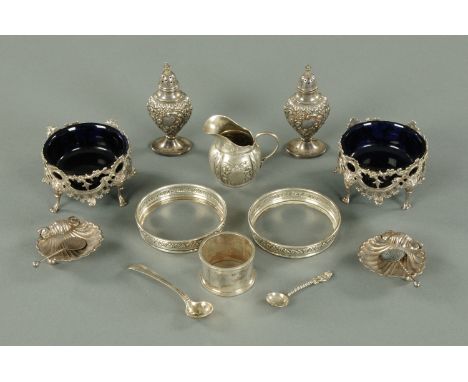A pair of silver plated salts with blue glass liners, pair of scallop shell salts with spoons, two silver pepperettes, servie