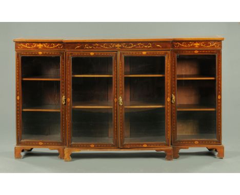 An Edwardian inlaid mahogany breakfront low bookcase, satinwood banded and boxwood and ebony strung, with four doors and rais