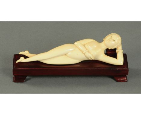 A Chinese ivory doctors model, early 20th century, typically carved as a naked recumbent female 15 cm long, on later wood sta