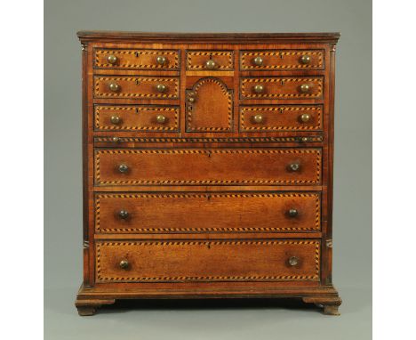 A George III oak North Country chest of drawers, the planked top with moulded edge above a series of drawers and cupboard fla