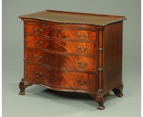 A George III style mahogany serpentine fronted chest of drawers, early 20th century, with carved moulded edge, slide and four