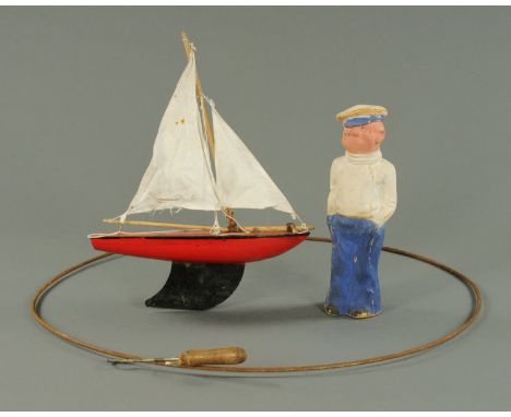 A vintage pressed cardboard Popeye figure. Height 36 cm, a pond yacht and a steel spinning loop.