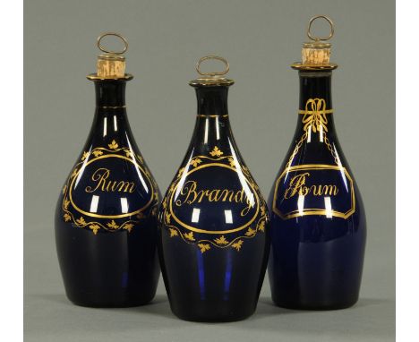 Three late Georgian blue Bristol glass decanters, two rum, one brandy.  Heights +/- 20 cm (see illustration).    CONDITION RE