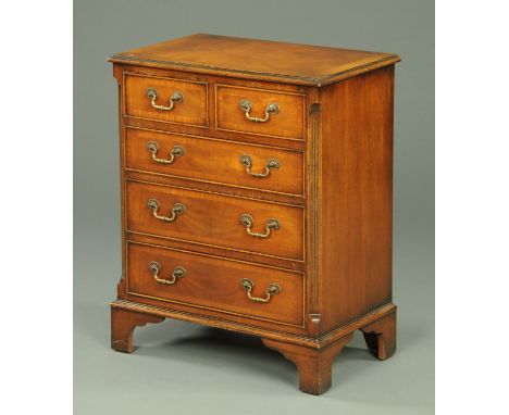 A mahogany chest of drawers, reproduction, with crossbanded moulded edge above two short and three long graduated with brass 