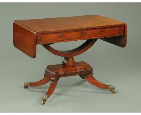 A Regency ebony strung sofa table, with cradle support and raised on four downswept legs terminating in brass castors.  Width