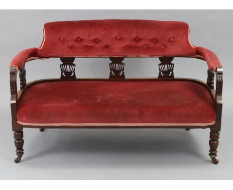 A late Victorian show-wood frame two-seater settee with buttoned back,  padded seat &amp; arms upholstered crimson velour, on