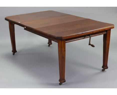 An Edwardian mahogany extending dining table with canted corners to the rectangular top, with centre leaf, wind-out mechanism