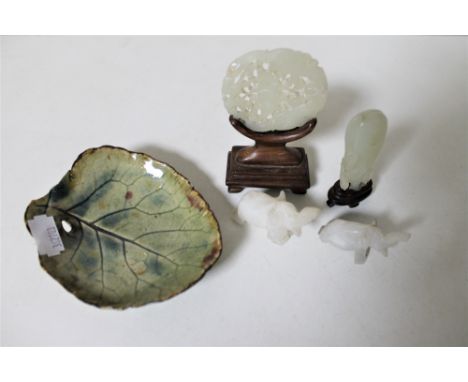 A Chinese jade carved disc on stand together with a further carved piece of jade on stand, two elephant figures and a leaf di