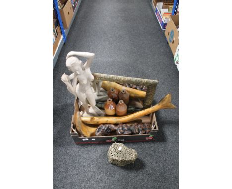 A box of two stoneware bottles, wooden fish ornaments, carved hardwood figure of a female, wicker framed mirror, concrete orn