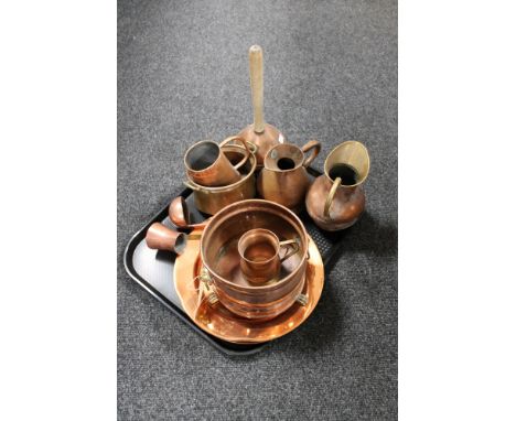 A tray of antique and later copper ware, poss stick, jugs, measures, twin handled planter  on brass paw feet 
