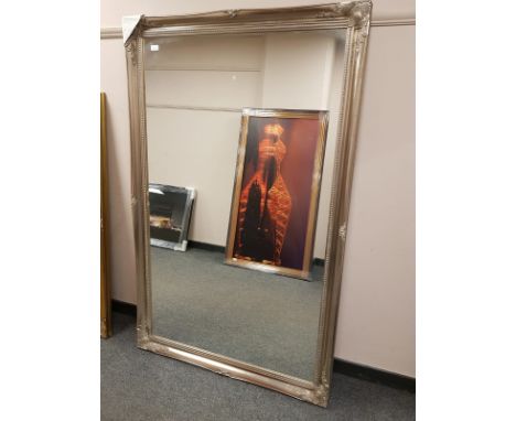 A silvered swept framed mirror 167 cm x 105 cm