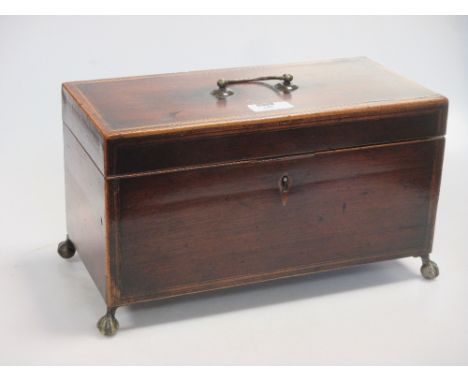 An early 19th century mahogany tea caddy on ball and claw feet  
