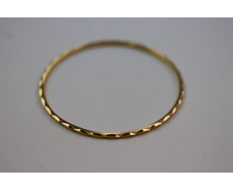 Unmarked yellow gold textured bangle, purchased in Dubai with receipt stating 22ct, inner circumference approximately 17.5cm