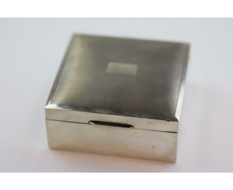 Silver cigarette box of square form, engine turned decoration to hinged lid, black rectangular cartouche to centre, makers Ha