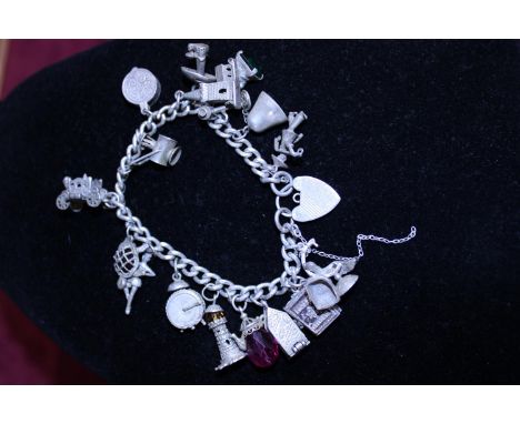 A hallmarked silver chain with white metal charms 