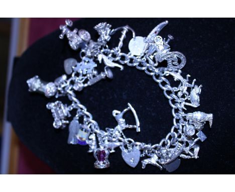 A hallmarked silver padlock chain with large selection of white metal charms (mostly silver) 