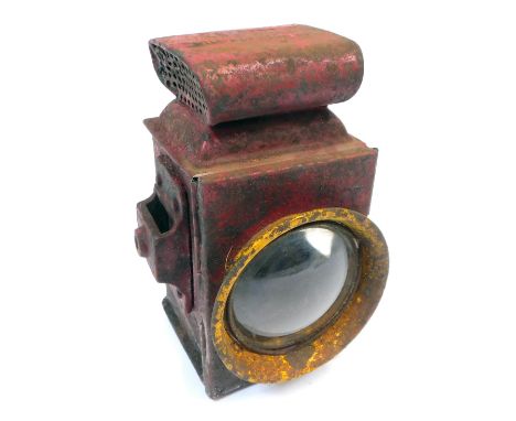 A late 19thC/early 20thC railway inspection lamp, in metal casing, painted in red with yellow floodlights, 19cm high, 11cm wi